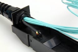 To support a design in which the trunk and cassette are integrated and deployed as one, the cable’s Kevlar and internal strength members are separated from the fiber inside the cassette and connected to an integrated strain relief to prevent any strain on the fibers themselves. To support a design in which the trunk and cassette are integrated and deployed as one, the cable’s Kevlar and internal strength members are separated from the fiber inside the cassette and connected to an integrated strain relief to prevent any strain on the fibers themselves.