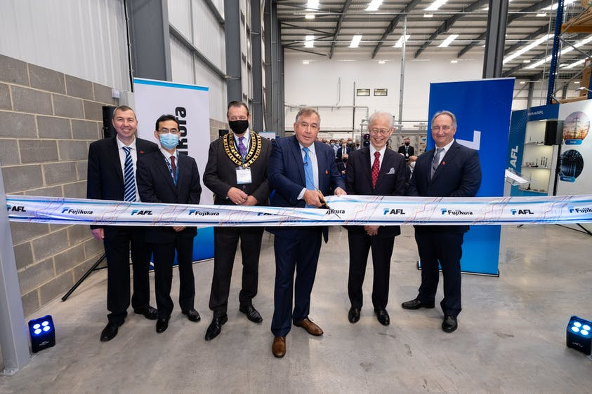 Cutting the ribbon as part of the opening ceremonies for AFL's new fiber cable production plant in Swindon, UK, are (from left to right) Paul Bennett, General Manager of AFL in Swindon, Toshitane Nakatsuji, Managing Director, Fujikura Europe Limited, Mayor of Swindon, Councillor Garry Perkins, Jody Gallagher, President and CEO of AFL, Mr. Hajime HAYASHI, Ambassador Extraordinary and Plenipotentiary of Japan to United Kingdom and Kurt Dallas, President AFL Product Solutions, AFL.