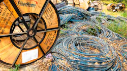 Chiang Mai/Thailand - April 17, 2019: Wooden and steel reels of black and blue telecommunication cables lying on the ground.