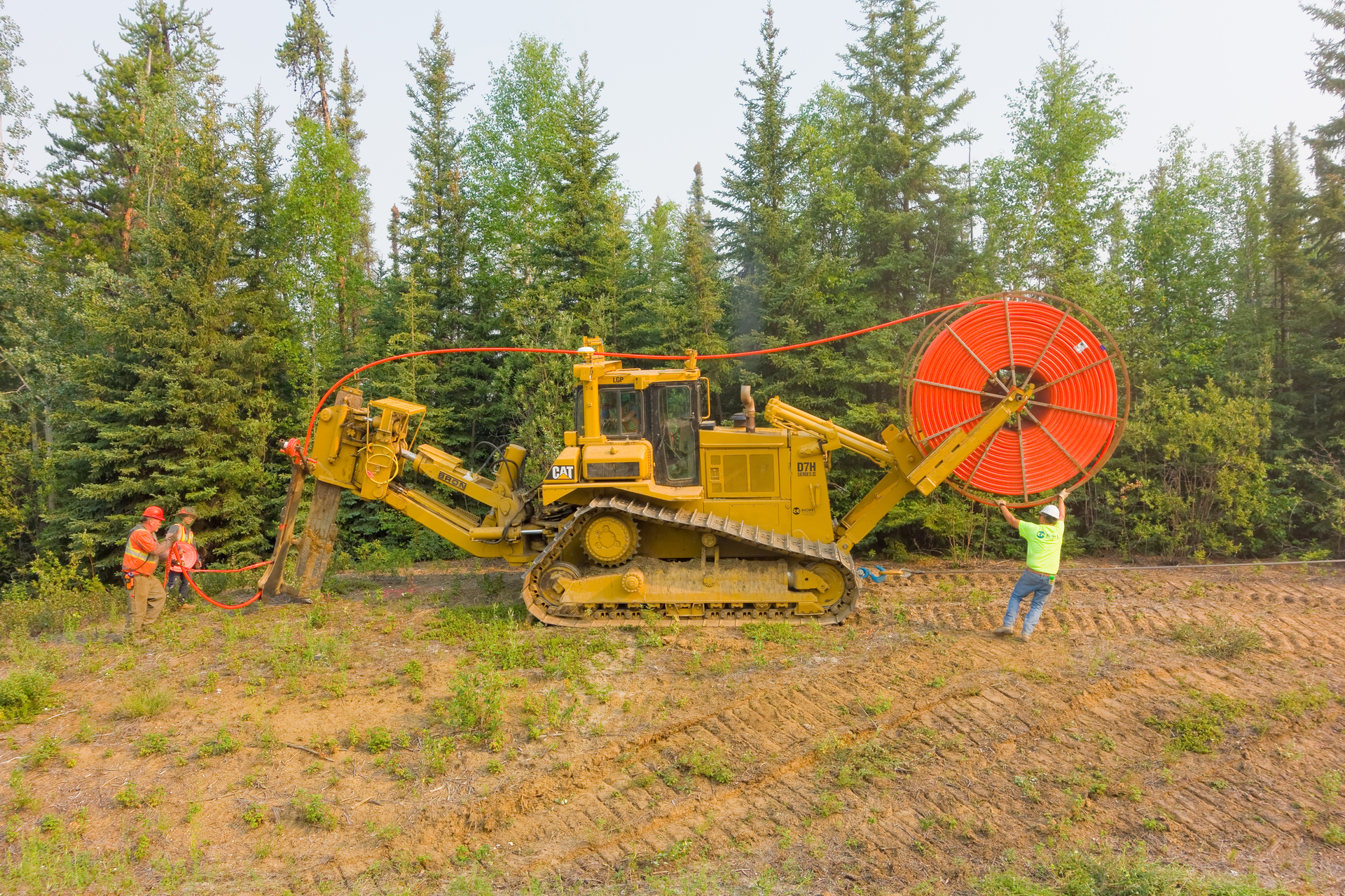 Workers laying fiber-optic cable.
