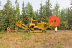 Workers laying fiber-optic cable. Workers laying fiber-optic cable.