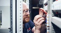 Marco Krause, a project manager for building automation at Bosch, works in a switch cabinet at Kaiserslautern University of Applied Sciences.