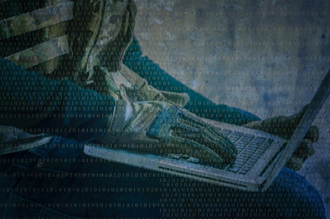 Camouflaged Hands Hacking Laptop